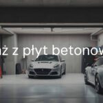 A sturdy concrete panel garage, modern design, parked car inside, tools on shelves, realistic lighting, durable construction.